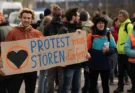 Aktivist*innen der Letzten Generation mit Schild "Protest muss stören dürfen"