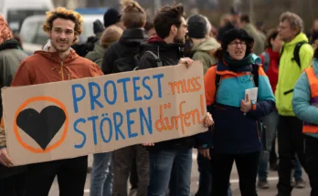 Aktivist*innen der Letzten Generation mit Schild "Protest muss stören dürfen"